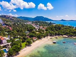 Beautiful aerial view of beach and sea with many tree and white Beautiful aerial view of beach and sea with many tree and white cloud on blue sky in koh samui island for vacation and travel