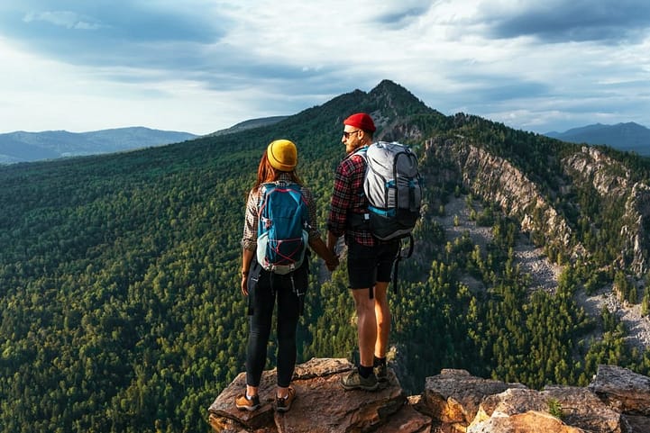 two tourists on the top of the mountain a man and a woman in the mountains